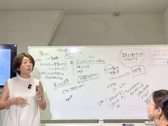 ホワイトボードと講師の近景