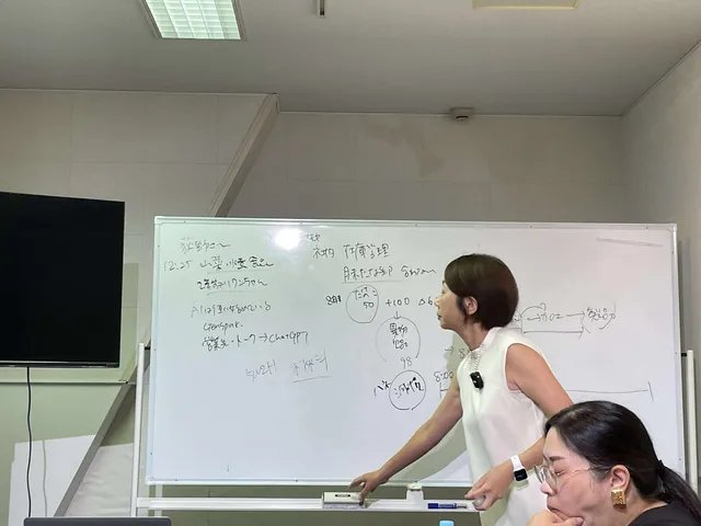 ホワイトボードと講師の近景